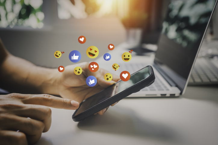 emojis flying out of a phone in a decorative manner